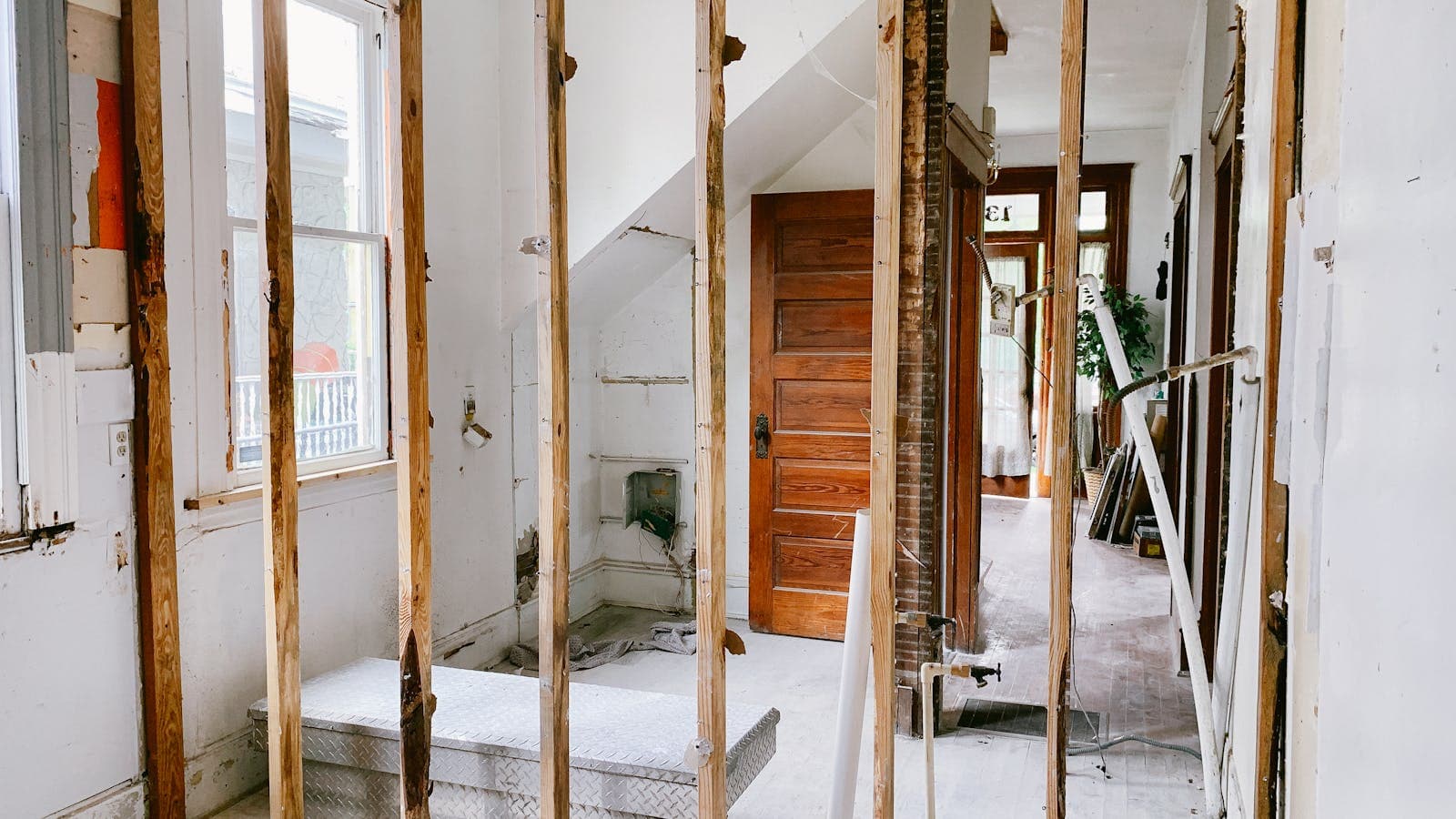 Interior demolition of a pre-1990 home showing exposed wall framing, old plaster, and aged wiring during a Vancouver, WA remodel
